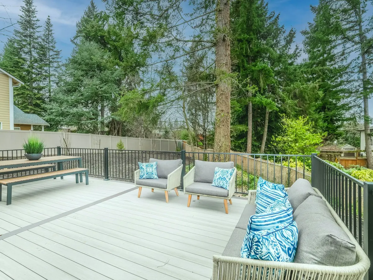 A finished backyard deck with a dining table and lounge chairs